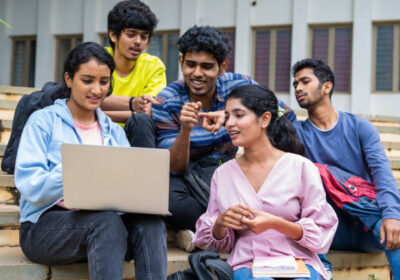 istockphoto-1461630610-612x612 Group of happy students checking results on laptop while sitting on college campus - concept of education, technology and project work discussion